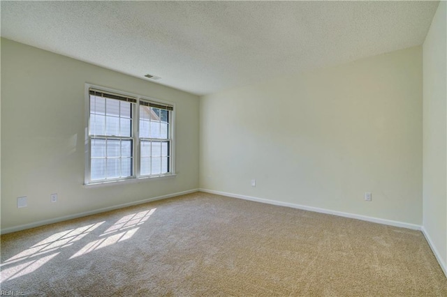 carpeted empty room featuring a textured ceiling