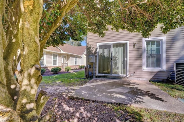 view of exterior entry featuring a patio and central AC