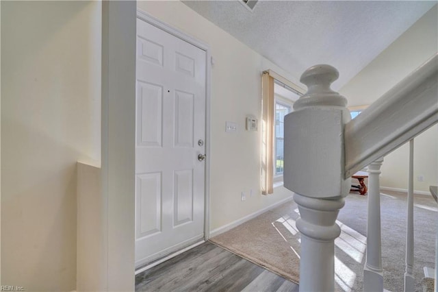 entryway with a textured ceiling and hardwood / wood-style flooring