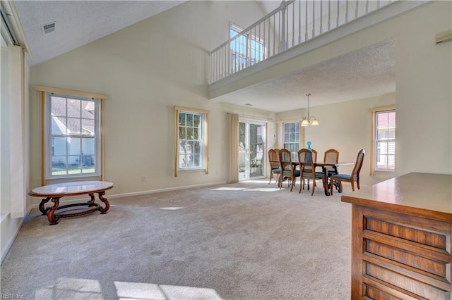 interior space with a notable chandelier, high vaulted ceiling, a healthy amount of sunlight, and a textured ceiling