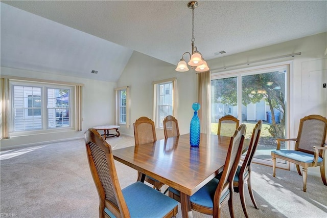 dining area featuring lofted ceiling, carpet, a textured ceiling, and a chandelier