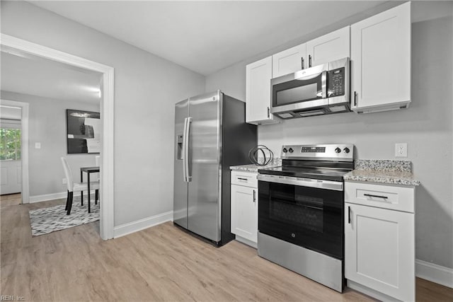 kitchen with white cabinetry, light stone counters, appliances with stainless steel finishes, and light wood-type flooring