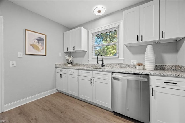 kitchen with light hardwood / wood-style flooring, white cabinetry, stainless steel dishwasher, and sink