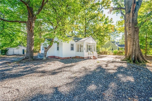 view of front facade with a storage shed and a sunroom