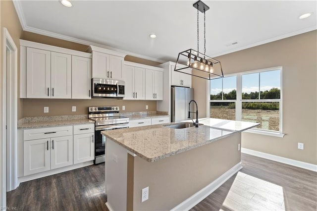 kitchen with stainless steel appliances, hanging light fixtures, an island with sink, and white cabinets