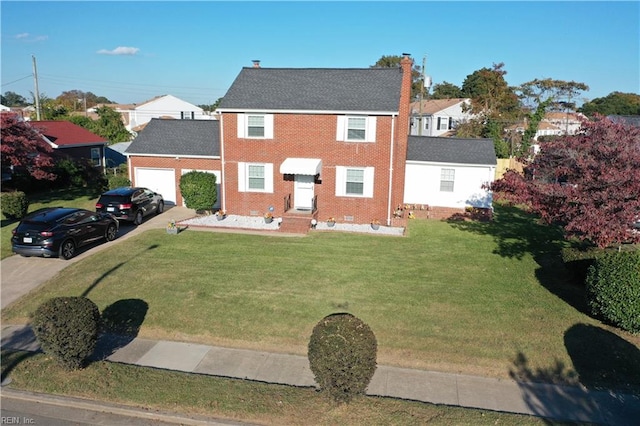 colonial-style house featuring a front yard and a garage