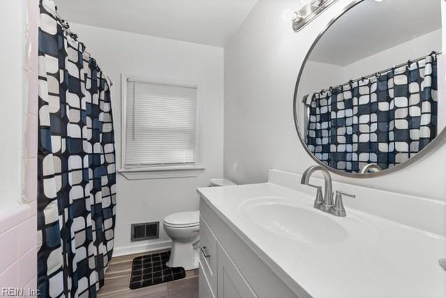 bathroom featuring vanity, toilet, and hardwood / wood-style flooring