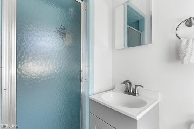 bathroom with vanity and a shower with shower door