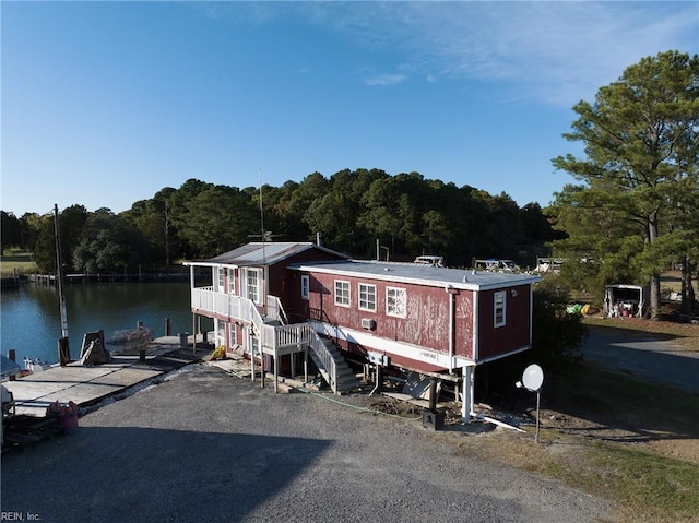 view of front of property with a water view and a dock