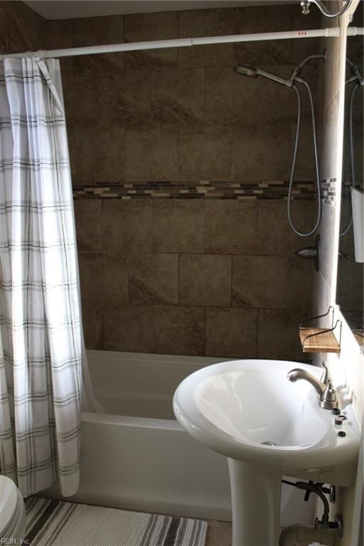 bathroom with shower / tub combo with curtain and toilet