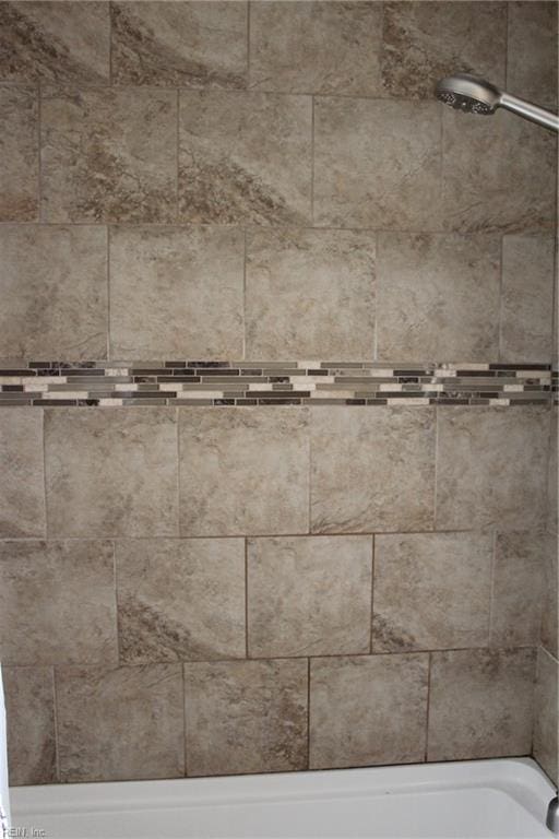 interior details featuring tiled shower / bath combo