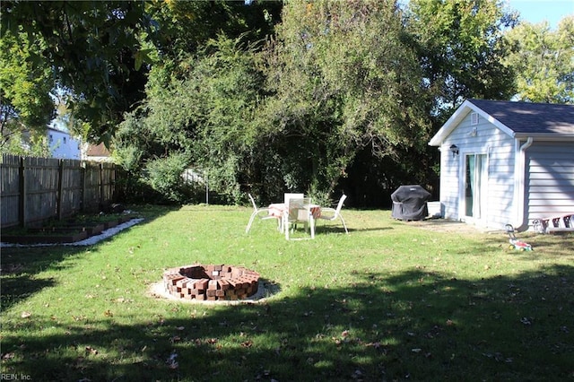 view of yard with an outbuilding and a fire pit