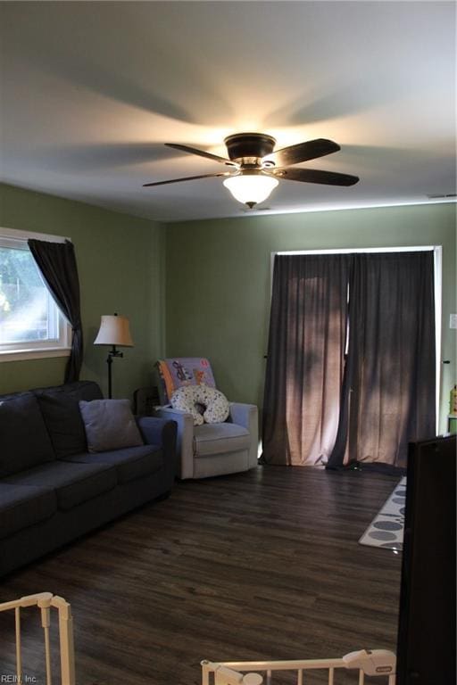 living room with dark hardwood / wood-style floors and ceiling fan