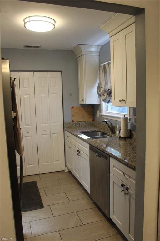 kitchen with dark stone countertops, sink, white cabinets, and dishwasher