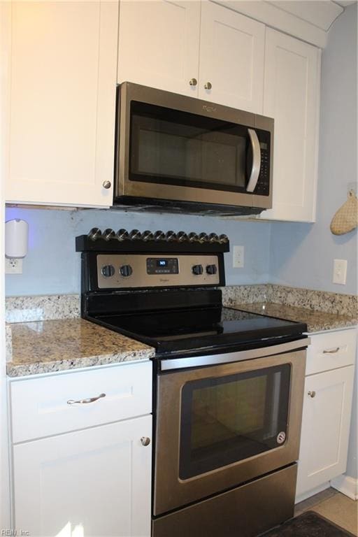 kitchen featuring light stone countertops, appliances with stainless steel finishes, and white cabinets