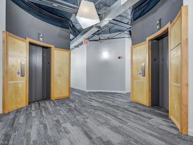 basement featuring elevator and dark colored carpet