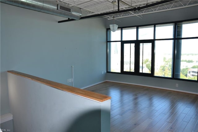 empty room featuring a healthy amount of sunlight and hardwood / wood-style flooring