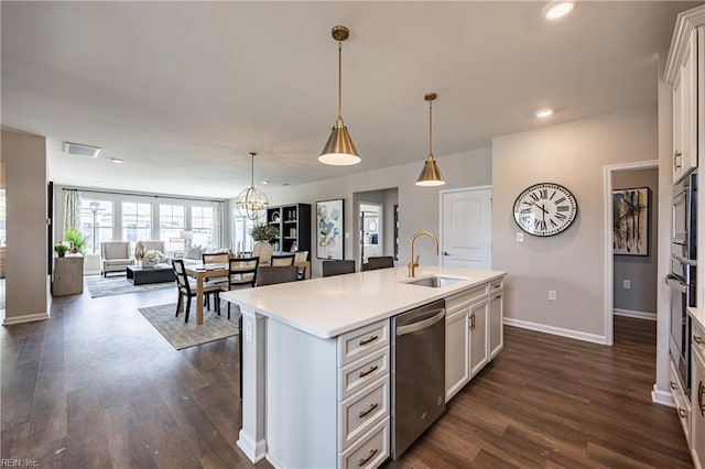 kitchen with an island with sink, stainless steel appliances, visible vents, a sink, and open floor plan