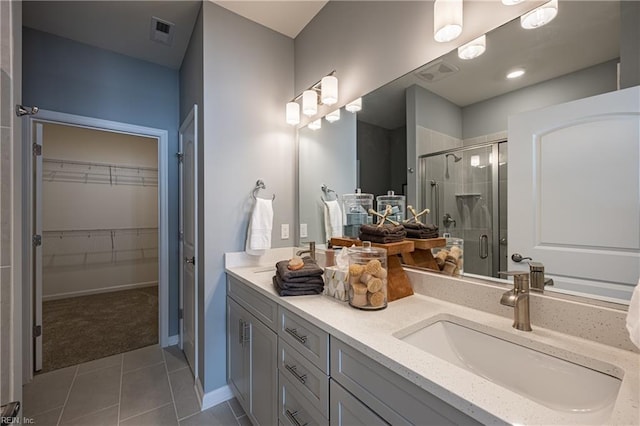 bathroom featuring walk in shower, tile patterned floors, and vanity