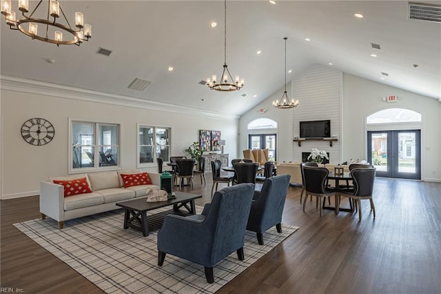 living room with wood-type flooring, a healthy amount of sunlight, a notable chandelier, and french doors