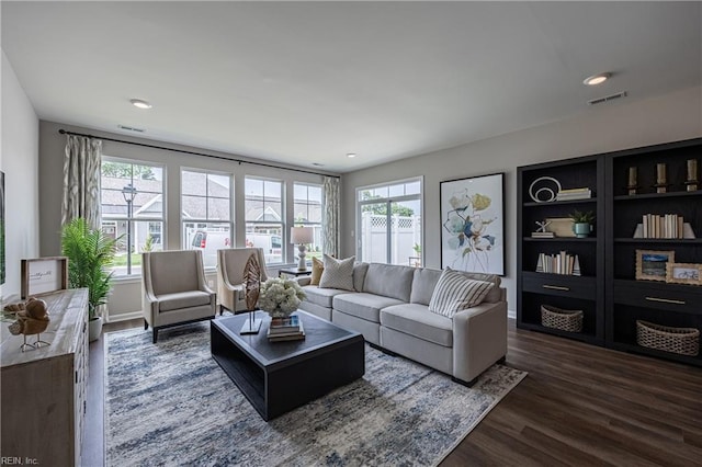 living room featuring a healthy amount of sunlight and dark hardwood / wood-style flooring