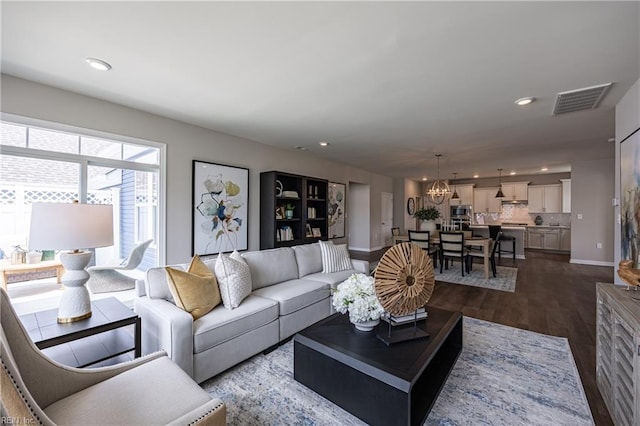 living room with recessed lighting, visible vents, an inviting chandelier, and dark wood-style floors
