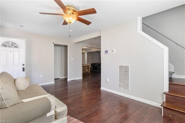 living room featuring dark wood-type flooring and ceiling fan