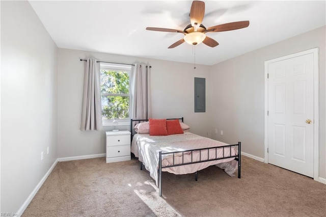 bedroom with ceiling fan, light carpet, and electric panel