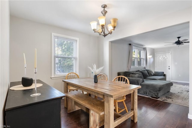 dining area with dark wood-type flooring and ceiling fan with notable chandelier