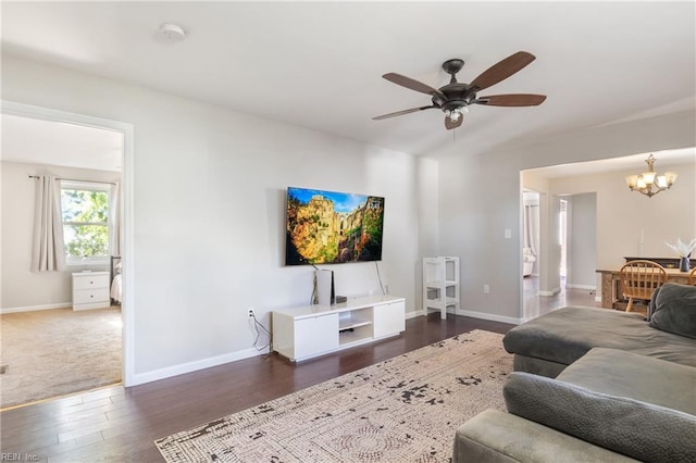 living room featuring dark hardwood / wood-style flooring and ceiling fan with notable chandelier