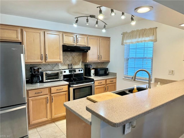 kitchen with light tile patterned floors, tasteful backsplash, appliances with stainless steel finishes, sink, and a breakfast bar