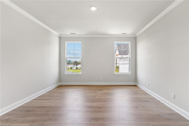 empty room featuring ornamental molding and light wood-type flooring