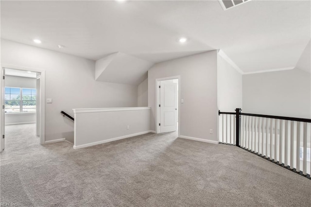 additional living space featuring light carpet and vaulted ceiling