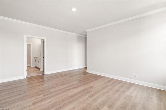 empty room with light hardwood / wood-style floors and crown molding