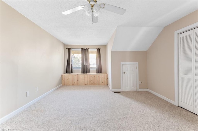 bonus room featuring a textured ceiling, ceiling fan, carpet, and vaulted ceiling