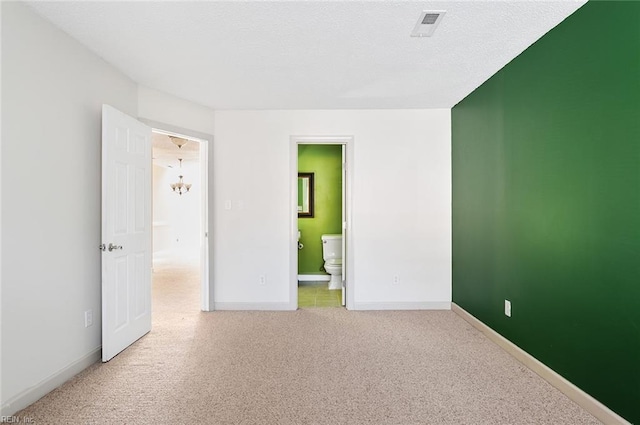 unfurnished bedroom with ensuite bath and light carpet