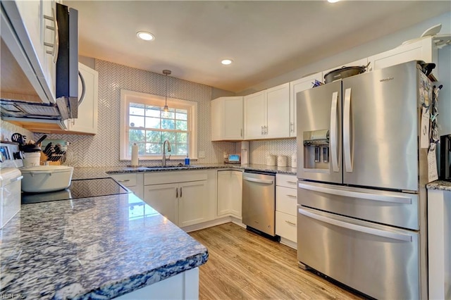 kitchen featuring light hardwood / wood-style flooring, sink, decorative light fixtures, white cabinetry, and appliances with stainless steel finishes