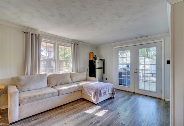 living room with french doors, wood-type flooring, and crown molding