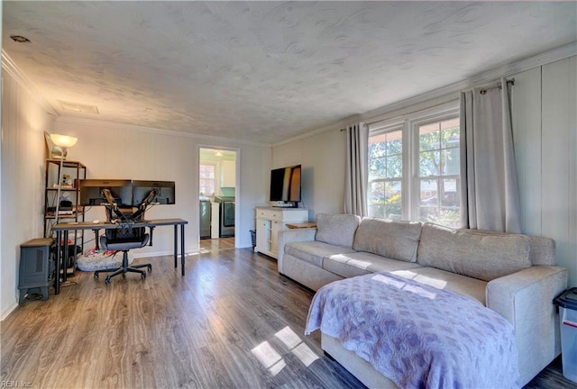 living room featuring ornamental molding, washer and dryer, and hardwood / wood-style flooring