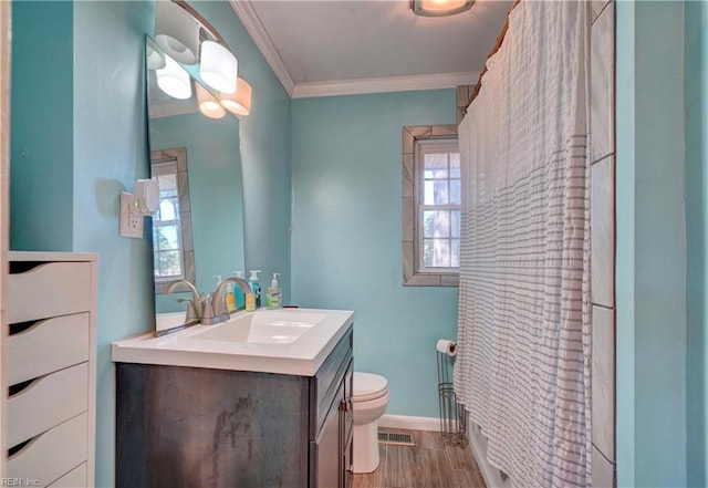 bathroom featuring vanity, ornamental molding, a healthy amount of sunlight, and toilet