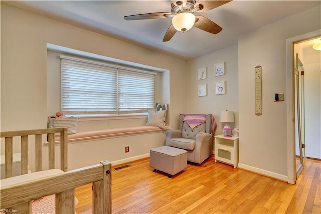 sitting room featuring light hardwood / wood-style floors and ceiling fan