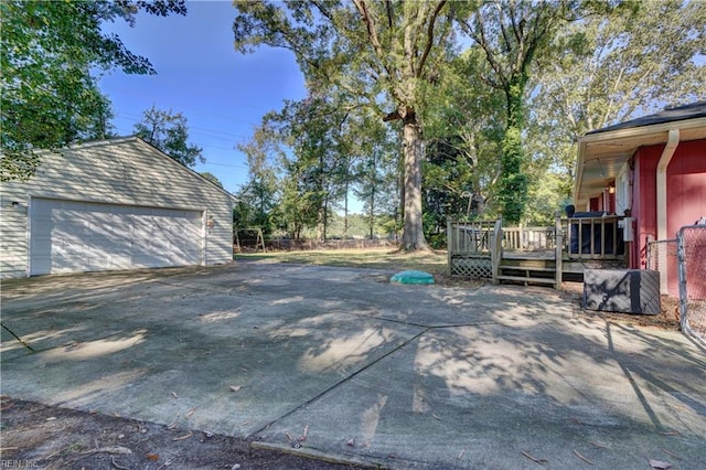 view of patio / terrace with an outbuilding, a wooden deck, and a garage