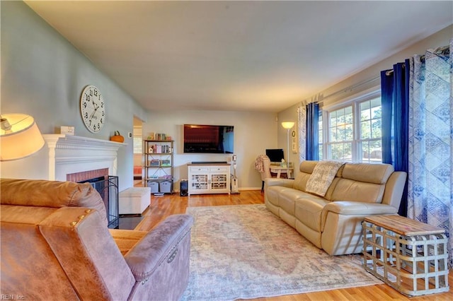 living room with hardwood / wood-style floors and a brick fireplace