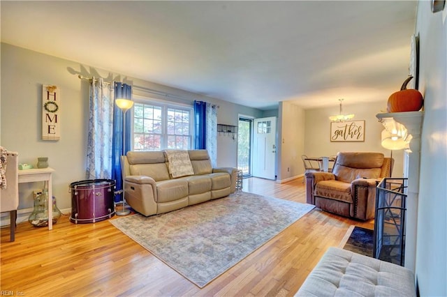 living room with a chandelier and light hardwood / wood-style flooring