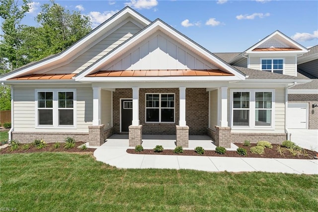 craftsman inspired home featuring a front yard and covered porch