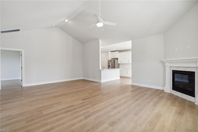 unfurnished living room with ceiling fan, lofted ceiling, and light hardwood / wood-style flooring