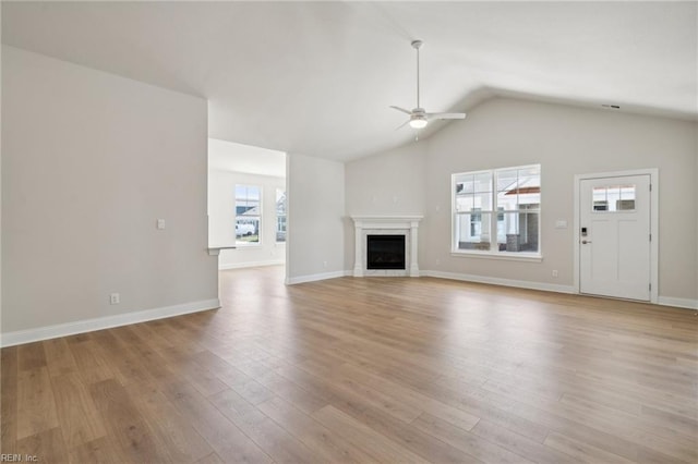 unfurnished living room featuring ceiling fan, vaulted ceiling, and light wood-type flooring