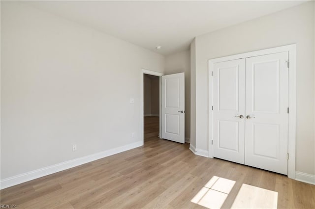 unfurnished bedroom with light hardwood / wood-style flooring and a closet