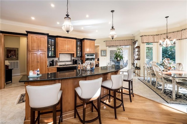 kitchen featuring ornamental molding, light hardwood / wood-style flooring, hanging light fixtures, and an inviting chandelier