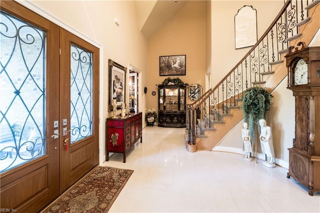 entrance foyer with french doors, tile patterned floors, and a high ceiling